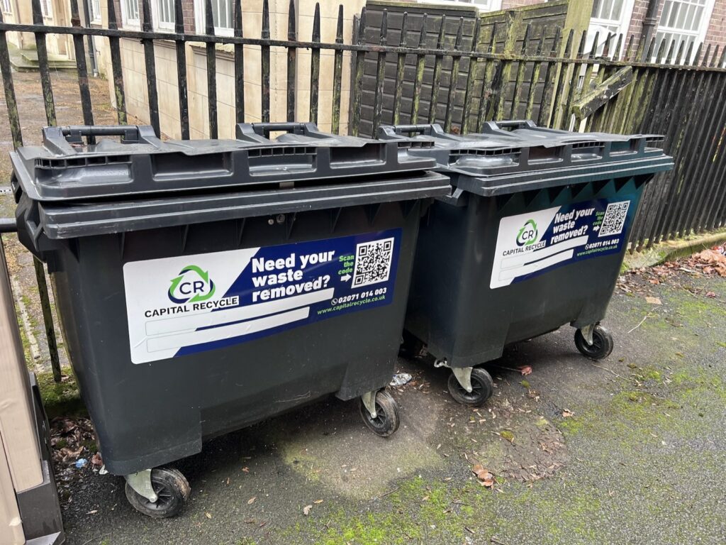 Two Capital Recycle 660 litre commercial wheelie bins on a London street