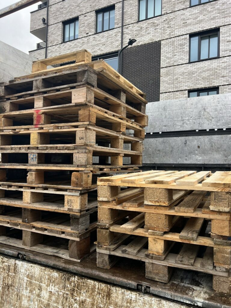 Used wooden pallets stacked on a truck bed after a London collection