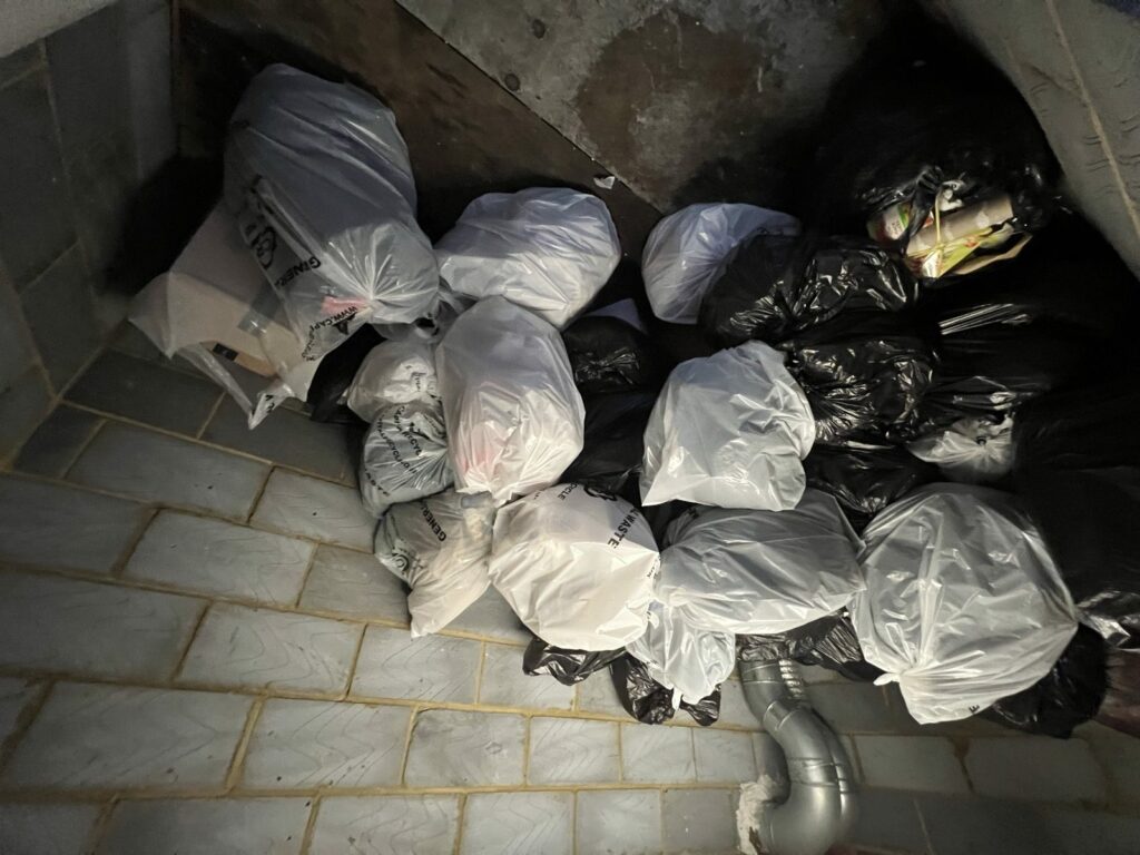 Waste sacks stacked in a commercial waste holding room ready for collection