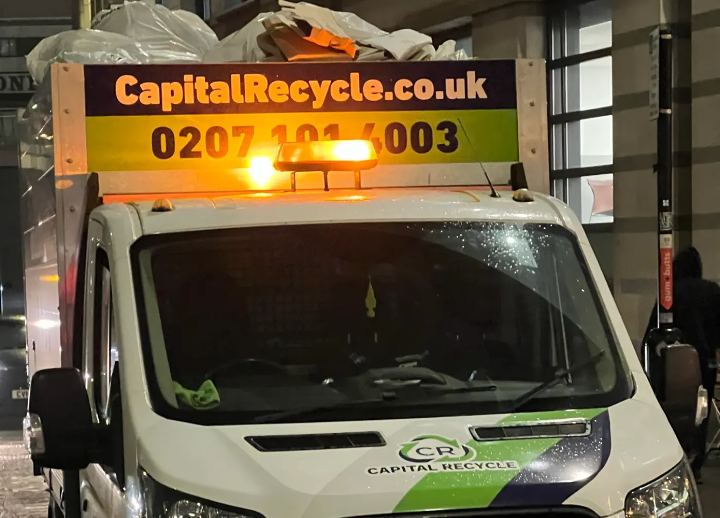 Capital Recycle caged tipper collecting office waste sacks on a City of London street in the evening
