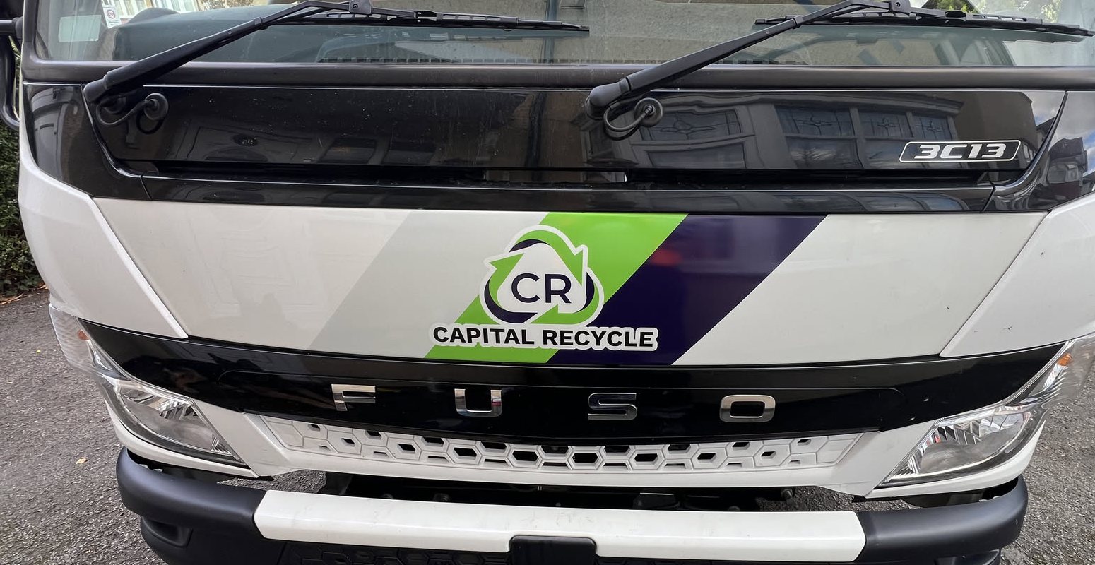 Capital Recycle logo with green and navy stripes on the front of our new caged tipper